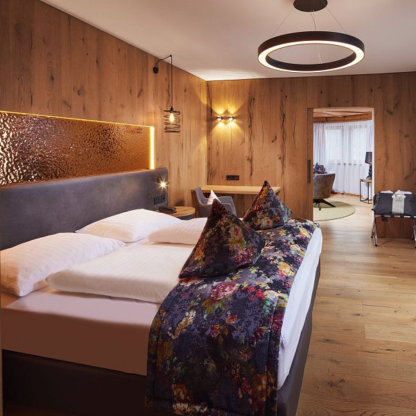 Elegantes Doppelzimmer mit goldener Wanddeko und farbenfrohen Polstern