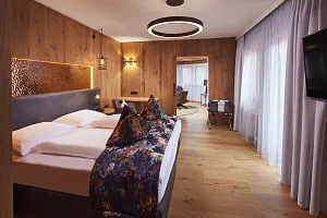 Elegantes Doppelzimmer mit goldener Wanddeko und farbenfrohen Polstern