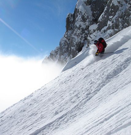 Skifahrer auf steiler Schneepiste