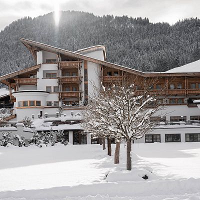 Das Sporthotel Ellmau von außen bei verschneiter Winterlandschaft
