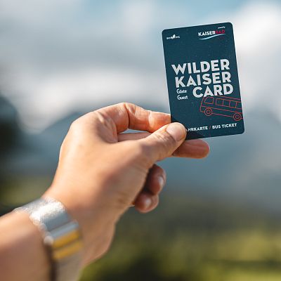 Eine Hand die eine Karte mit der Aufschrift „Wilder Kaiser Gäste Card“ hält.
