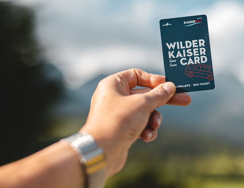 Eine Hand die eine Karte mit der Aufschrift „Wilder Kaiser Gäste Card“ hält.